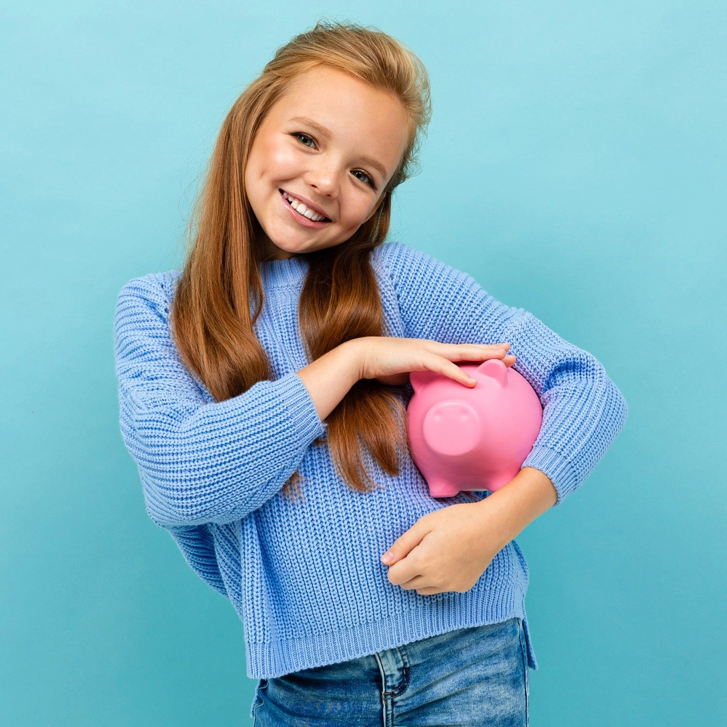 Atrium Sports e.V. - Kampfsport und Fitness – ein junges Mädchen hält glücklich ein rosa Sparschwein in der Hand, das häufig als Symbol für Geldsparen und Finanzkompetenz verwendet wird.