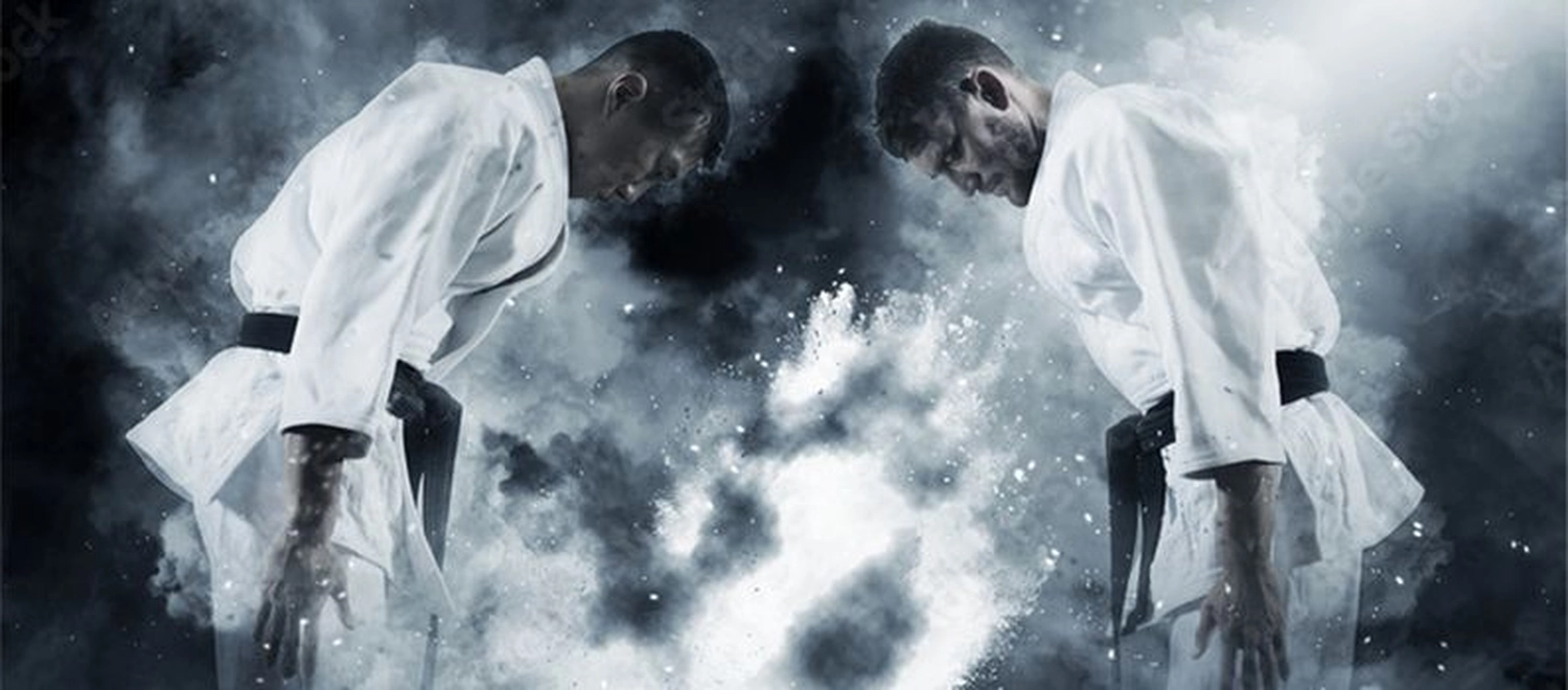 Atrium Sports e.V. – Kampfsport und Fitness – Zwei Kampfsportler in weißen Gis mit schwarzem Gürtel verbeugen sich respektvoll voreinander